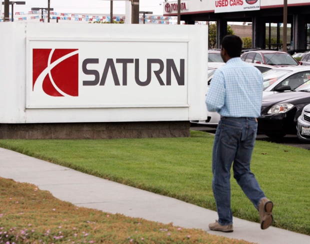 A customer looks at several different Saturn models for sale at a Saturn dealership in San Jose, Calif., Friday, June 5, 2009.  (AP / Paul Sakuma)