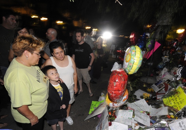 A week after after the death of Michael Jackson crowds still gather early Friday morning at a makeshift memorial outside the family home of the late pop star, in the Encino neighborhood of Los Angeles, July 3, 2009. (AP / Gus Ruelas)