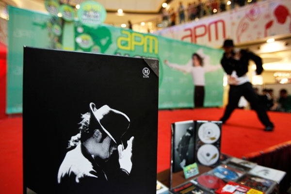 A fan of Michael Jackson dances near some albums of the superstar at a shopping mall in Hong Kong, Sunday, July 5, 2009. (AP / Vincent Yu)