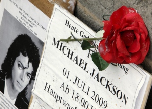 A placard and rose are seen following a commemorative gathering for late U.S. singer Michael Jackson, in front of a church in Frankfurt, central Germany, Tuesday, July 7, 2009. (AP / Michael Probst)