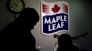 A Maple Leaf Foods employee, right, signs in a person at the company's meat facility in Toronto on December, 15, 2008. THE CANADIAN PRESS/Nathan Denette