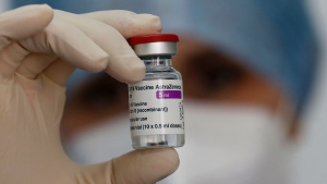 A health worker holds up a dose of the AstraZeneca vaccine against COVID-19 to be administered to members of the Italian Army at a vaccination center set up at the military barracks of Cecchignola, in Rome, Tuesday, Feb. 23, 2020. (Cecilia Fabiano/LaPresse via AP)