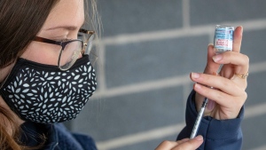 Georgia Mates, prepares a Moderna COVID-19 vaccine ahead of a drive-thru clinic at Richardson stadium in Kingston, Ont., on Friday, Jul. 2, 2021. THE CANADIAN PRESS/Lars Hagberg 