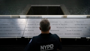 NYPD officer Michael Dougherty, a 25-year veteran, stands beside the south reflecting pool of the 9/11 Memorial & Museum where names of his deceased colleagues and friends are displayed, Monday, Aug. 16, 2021, in New York. (AP Photo/John Minchillo)