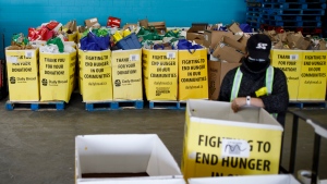 A volunteer organizes boxes for food at the Daily Bread Food Bank's Spring Drive-Thru food drive at the food bank in Etobicoke, Ontario on Saturday, April 3, 2021. THE CANADIAN PRESS/Cole Burston