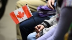 A young new Canadian holds a flag as she takes part in a citizenship ceremony on Parliament Hill in Ottawa on Wednesday, April 17, 2019, to mark the 37th anniversary of the Canadian Charter of Rights and Freedoms. THE CANADIAN PRESS/Sean Kilpatrick