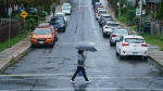 FILE - A person carries an umbrella during a downpour of rain in Toronto on Tuesday, Sept. 27, 2022. THE CANADIAN PRESS/Alex Lupul 