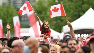 A child waves the Maple Leaf flag during Canada Day celebrations at LeBreton Flats in Ottawa, on Friday, July 1, 2022. THE CANADIAN PRESS/Justin Tang