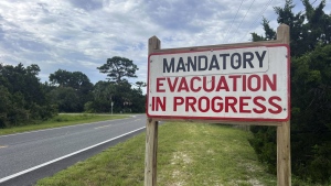 An evacuation sign stands in Cedar Key, Fla., on Tuesday, Aug. 29, 2023. Idalia strengthened into a hurricane Tuesday and barreled toward Florida's Gulf Coast as authorities warned residents of vulnerable areas to pack up and leave to escape the twin threats of high winds and devastating flooding. (AP Photo/Daniel Kozin)