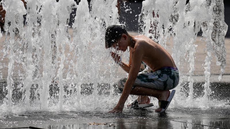 A boy cools off in a fountain at the city center of Budapest, Hungary, during a heatwave with 35 degrees Celsius on Saturday, Aug. 26, 2023. (AP Photo/Martin Meissner)