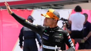 FILE - McLaren driver Lando Norris of Britain arrives to the paddock before the Formula One Monaco Grand Prix race at the Monaco racetrack, in Monaco, Sunday, May 26, 2024. (AP Photo/Luca Bruno)