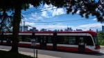 A Toronto Transit Commission streetcar drives past the downtown skyline in Toronto on Thursday June 6, 2024. THE CANADIAN PRESS/Frank Gunn
