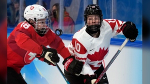 FILE -Switzerland's Stefanie Wetli (18) and Canada's Sarah Fillier (10) battle for the puck during a women's semifinal hockey game at the 2022 Winter Olympics, Monday, Feb. 14, 2022, in Beijing. Sarah Fillier is ready to shelve her Princeton education and focus on hockey in entering the PWHL draft, where she is projected to be selected first on Monday, JUne 10, 2024. (AP Photo/Petr David Josek, File)