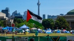 A Palestinian flag flies over the pro-Palestinian encampment set up at the University of Toronto campus, in Toronto, Sunday, May 26, 2024. (The Canadian Press/Frank Gunn)