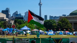 A Palestinian flag flies over the pro-Palestinian encampment set up at the University of Toronto campus, in Toronto, Sunday, May 26, 2024. (The Canadian Press/Frank Gunn)