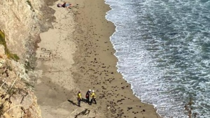 The word 'HELP' made with rocks is seen on a beach during the rescue of a stranded kite surfer south of Davenport Landing in Santa Cruz County. (Cal Fire/KOVR via CNN Newsource)
