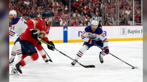 Edmonton Oilers center Connor McDavid (97) skates with the puck as Florida Panthers center Sam Bennett (9) defends during the first period of Game 2 of the NHL hockey Stanley Cup Finals, Monday, June 10, 2024, in Sunrise, Fla. (AP Photo/Wilfredo Lee)