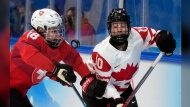 FILE -Switzerland's Stefanie Wetli (18) and Canada's Sarah Fillier (10) battle for the puck during a women's semifinal hockey game at the 2022 Winter Olympics, Monday, Feb. 14, 2022, in Beijing. Sarah Fillier is ready to shelve her Princeton education and focus on hockey in entering the PWHL draft, where she is projected to be selected first on Monday, June 10, 2024. (AP Photo/Petr David Josek, File)