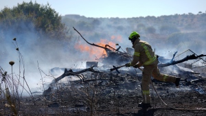 An Israeli firefighter works to extinguish a fire burning in an area near the community of Ramot Naftali, by the border with Lebanon, northern Israel, Tuesday, June 4, 2024. (AP Photo/Ariel Schalit)