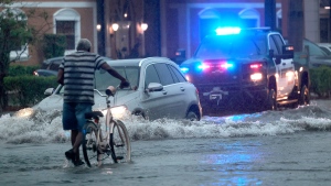 A bicyclist goes through flooded streets on Stirling Road near Federal Highway in Hollywood, Fla., Wednesday, June 12, 2024. (Mike Stocker/South Florida Sun-Sentinel via AP)