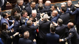5-Star Movement lawmaker Leonardo Donno, centre top, is protected by parliament employees from other lawmakers during brawl in the lower chamber of deputies at the Italian parliament, in Rome, Wednesday, June 12, 2024. (Mauro Scrobogna/LaPresse via AP)