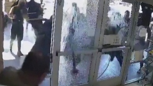 About 20 robbers storm a jewelry store in California and are seen smashing display cases and running away with items.
