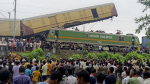 Onlookers watch as rescuers work after a cargo train rammed into Kanchanjunga Express, a passenger train, near New Jalpaiguri station, West Bengal state, India, Monday, June 17, 2024. (AP Photo/Diptendu Dutta)