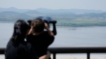 Visitors use binoculars to see the North Korean side from the unification observatory in Paju, South Korea, Sunday, June 9, 2024. (AP Photo/Lee Jin-man)