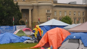 A supporter walks through the pro-Palestinian student encampment outside Convocation Hall on the University of Toronto campus, in Toronto, Monday, May 27, 2024. THE CANADIAN PRESS/Chris Young 