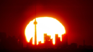 A new report by Statistics Canada says deaths in the country's 12 highest-population cities go up on days when there is extreme heat. The sun rises over the Toronto skyline on Saturday, May 1, 2021. THE CANADIAN PRESS/Frank Gunn
