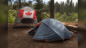 Summer is peak travel season for Canadians, with July the most popular time for a getaway. A recent Deloitte poll found 37 per cent of respondents plan to take a trip during the month. Campers with a Canadian flag flying on their camp site are shown in Algonquin Park in Ontario on Saturday June 12, 2021. THE CANADIAN PRESS/Fred Thornhill