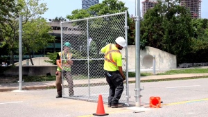 Crews are shown putting up fencing restricting access to the Ontario Science Centre on June 21.  