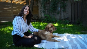 Victim Services Toronto employee Megan Ireland and Labrador retriever Penny pose for a photograph in Toronto on Friday, June 14, 2024. (The Canadian Press/Nathan Denette)