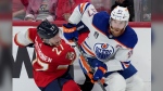 Edmonton Oilers forward Connor McDavid (97) dumps Florida Panthers forward Eetu Luostarinen (27) against the boards as he turns with the puck during second period game 7 of the NHL Stanley Cup finals in Sunrise, Fla., on Monday, June 24, 2024. THE CANADIAN PRESS/Nathan Denette