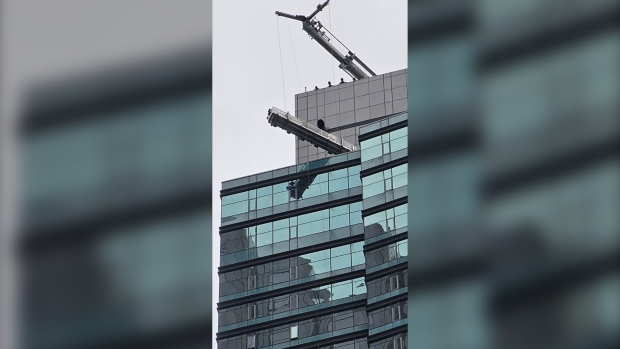 A loose swing stage dangles from the St. Regis Hotel after some of its ropes broke Tuesday June 25, 2024. (Submitted)