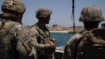 U.S. Army soldiers stand at the U.S.-built floating pier Trident backdropped by the coast of the Gaza Strip, Tuesday, June 25, 2024. (AP Photo/Leo Correa)