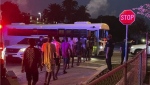 In this photo provided by the Monroe County Sheriff's Office, a group of over 100 migrants from Haiti are shown being loaded onto buses after they arrived off Key West, Fla., in a sailboat early Wednesday, June, 26, 2024. (Monroe County Sheriff's Office via AP)