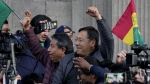 Bolivian President Luis Arce raises a clenched fist surrounded by supporters and media, outside the government palace in La Paz, Bolivia, Wednesday, June 26, 2024. (Juan Karita/AP Photo)