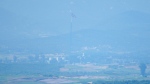 A North Korean flag flutters in the wind atop a 160-metre tall tower in the North's Kijong-dong village near the truce village of Panmunjom, seen from Paju, South Korea, June 26, 2024. (AP Photo/Lee Jin-man)