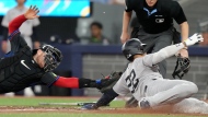 New York Yankees outfielder Juan Soto (22) slides safe into home as Toronto Blue Jays catcher Danny Jansen (9) fails to make the tag during fourth inning American League MLB baseball action in Toronto, Friday, June 28, 2024. THE CANADIAN PRESS/Chris Young