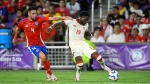 Canada's Alphonso Davies, right, takes a shot on goal while Chile's Mauricio Isla defends during a Copa America Group A soccer match in Orlando, Fla., Saturday, June 29, 2024. (AP Photo/Phelan Ebenhack) 