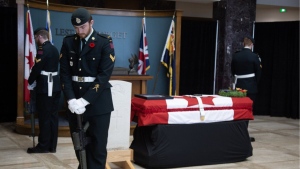 Members of the Royal Newfoundland Regiment stand guard over the remains of an Unknown Newfoundland soldier as he lies in state at the Confederation Building in St. John's on Friday, June 28, 2024. (The Canadian Press/Paul Daly)