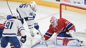 Toronto Maple Leafs' Mitch Marner (16) moves in on Montreal Canadiens goaltender Cayden Primeau as Leafs' John Tavares (91) looks on during third period NHL hockey action in Montreal, Saturday, April 6, 2024. (The Canadian Press/Graham Hughes0