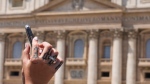 A woman sporting a tattoo with the word "Hope" on her hand films Pope Francis' Angelus noon prayer in St. Peter's Square at the Vatican, Sunday, July 9, 2023. (AP Photo/Gregorio Borgia)
