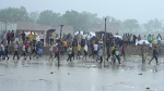 Villagers crowd at the site of Tuesday's stampede as it rains in Hathras district, Uttar Pradesh, India, Wednesday, July 3, 2024. Severe overcrowding and a lack of exits contributed to a stampede at a religious festival in northern India, authorities said Wednesday, leaving more than 100 people dead as the faithful surged toward the preacher to touch him and chaos ensued. (AP Photo/Rajesh Kumar Singh)