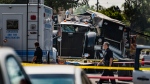 Police officers walk past the remains of an armored Los Angeles Police Department tractor-trailer July 1, 2021, after illegal fireworks seized at a home exploded in South Los Angeles. (AP Photo/Damian Dovarganes, File)
