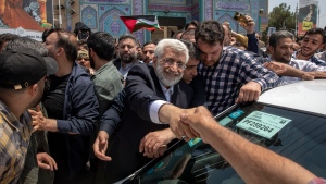 Candidate for the Iran's presidential election Saeed Jalili, a hard-line former nuclear negotiator, shakes hand with a supporter after casting his vote for the presidential runoff election in Qarchak near Tehran, Iran, Friday, July 5, 2024. (AP Photo)