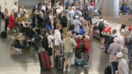 Holiday travellers wait for their luggage after arriving at Salt Lake City International Airport Wednesday, July 3, 2024, in Salt Lake City. (AP Photo/Rick Bowmer)