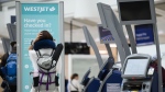 Passengers are seen in the WestJet check-in area at Pearson International Airport, in Toronto on June 29, 2024. THE CANADIAN PRESS/Christopher Katsarov