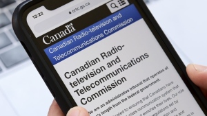 A person navigates to the on-line social-media pages of the Canadian Radio-television and Telecommunications Commission (CRTC) on a cell phone in Ottawa on May 17, 2021. THE CANADIAN PRESS/Sean Kilpatrick